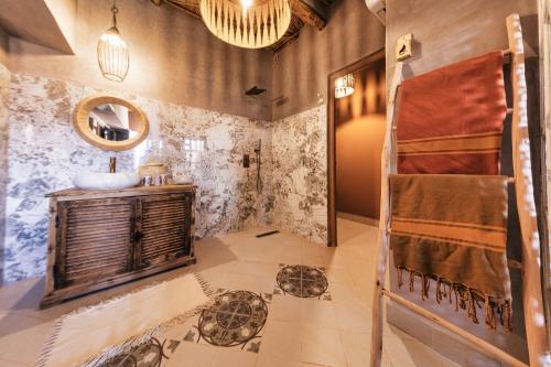 a bathroom with a shower and a sink and a mirror at Ksar Ighnda in Aït Ben Haddou