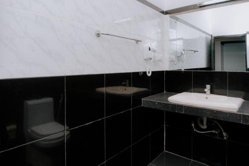 a black and white bathroom with a sink and a mirror at Auraya Ella in Ella