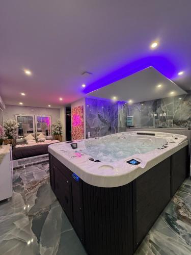 a large bathroom with a large tub with purple lighting at Vegas Spa in Limay