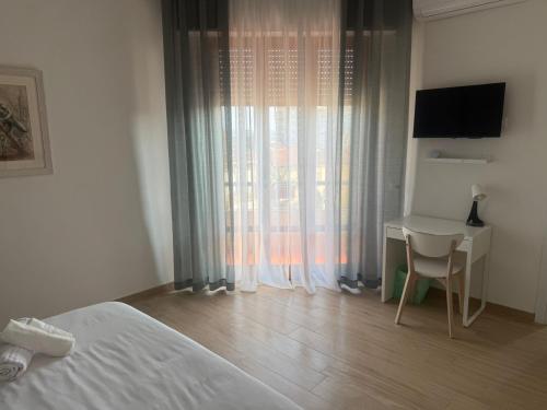 a bedroom with a bed and a desk and a window at Casa La Perla in Montevarchi
