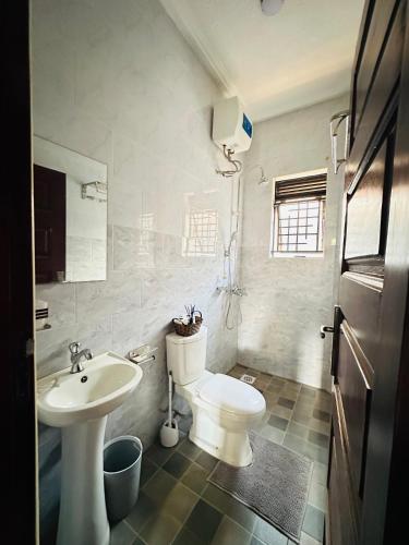 a white bathroom with a sink and a toilet at True's cozy homes in Kira