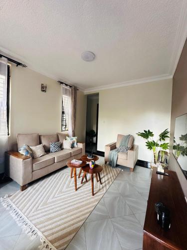 a living room with a couch and a table at True's cozy homes in Kira