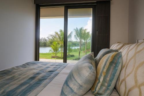 a bedroom with a bed with a view of the water at Villa Serenity Seafront with Tropical Gardens by Serenity in Calodyne
