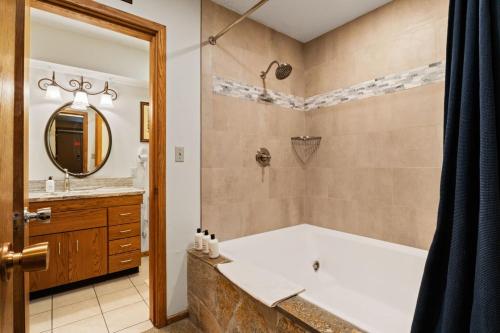 a bathroom with a tub and a sink at RMR: Wind River 4 Condo in Teton Village in Teton Village