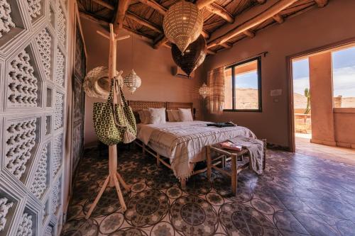 a bedroom with a bed and a table at Ksar Ighnda in Aït Ben Haddou