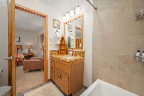 um banheiro com uma pia e um espelho em RMR: Wind River 5 Condo in Teton Village em Teton Village