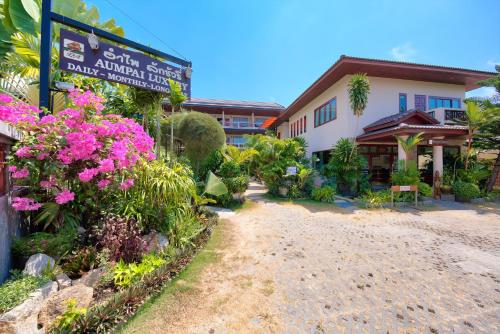 a building with a sign and flowers in front of it at Aumpai Luxury in Lamai