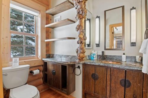 Un baño con inodoro, lavabo y espejo. en RMR: Teton View Cabin Home in WilsonWY, en Wilson