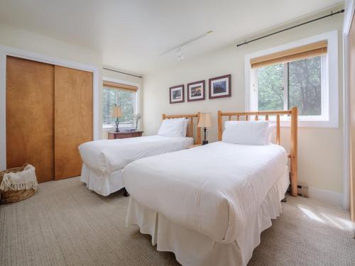 Dos camas en una habitación con dos ventanas. en RMR: Sleeping Indian West 4 Condo in Teton Village, en Teton Village
