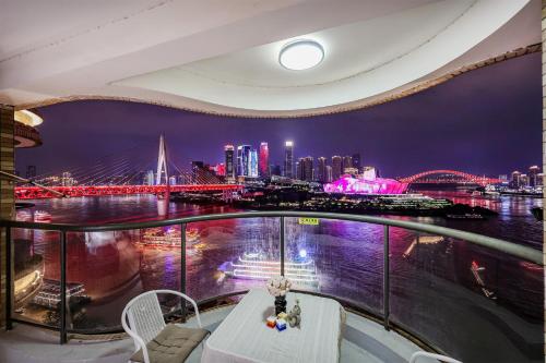 a balcony with a view of a city at night at Deptour Riverview aparment-ChaoTianMen in Chongqing