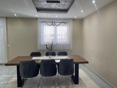 コソフスカ・ミトロビツァにあるLuxury Homeの木製のテーブルと椅子のあるダイニングルーム