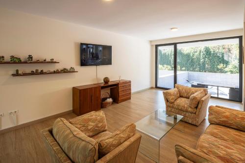 a living room with a couch and chairs and a tv at Beautiful house 15 min away from Bilbao in Llodio