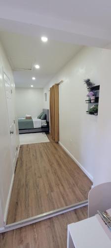 ein Wohnzimmer mit einem Bett und Holzboden in der Unterkunft Cozy Studio Walk to Shops, Quick Drive to DC in Silver Spring