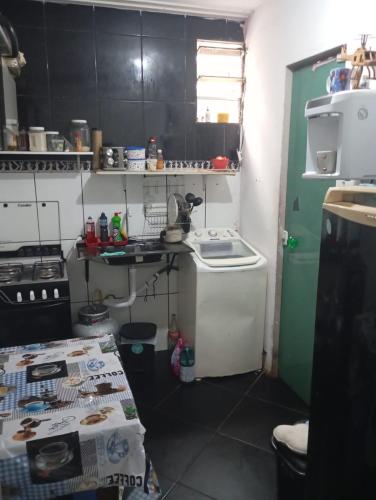 a small kitchen with black cabinets and a green door at Cop 30 in Belém