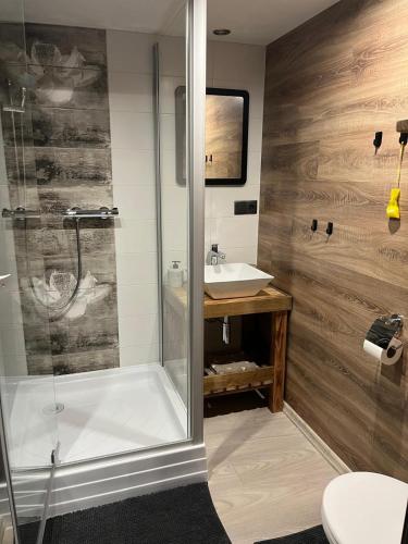 a bathroom with a shower and a tub and a sink at Víkendový dom pod Sidorovom in Ružomberok