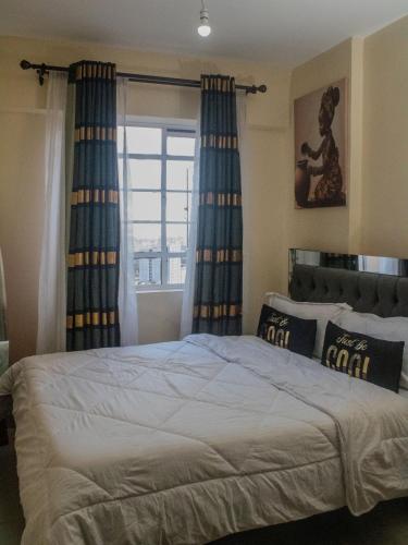 a bedroom with a bed with blue curtains and a window at Casa Almasi in Nairobi