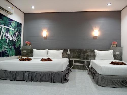 two beds in a hotel room with towels on them at Lanta Beautiful beach house in Ko Lanta