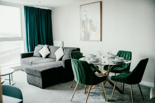 a living room with a table and green chairs at Exclusive 2BR Apartments By Luxus in Belfast