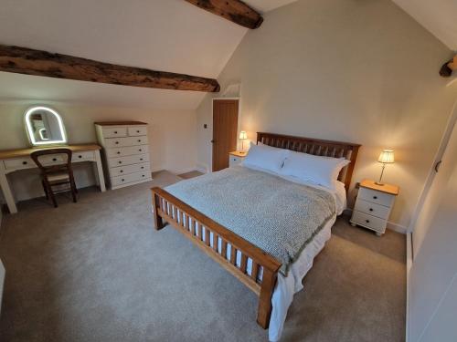 a bedroom with a bed with a desk and a bed sidx sidx sidx sidx sidx at Malthouse Barn, Staffordshire in Gnosall