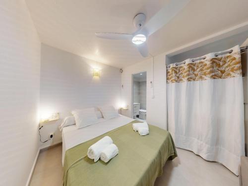 a white bedroom with a bed with towels on it at Anoli Studio Location in Les Trois-Îlets