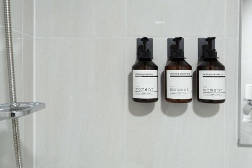 a group of three bottles on a wall in a bathroom at stay105행궁 in Suwon