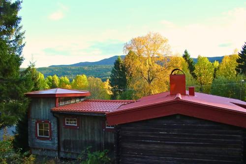 Un pequeño edificio con techo rojo en el bosque. en Cozy cabin with an amazing view, en Åre