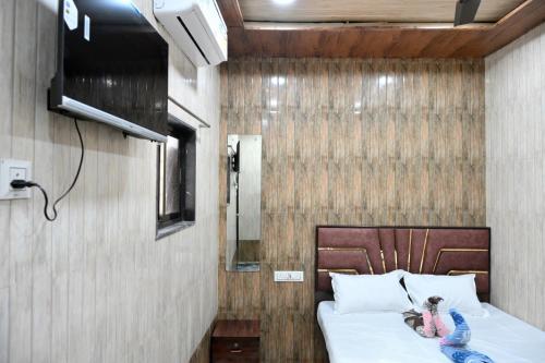 a little girl sitting on a bed in a room at Hotel Bhagirath in Mumbai