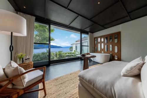 a bedroom with a tub and a bed and a chair at Dali Lanting Seaview Hotel in Dali