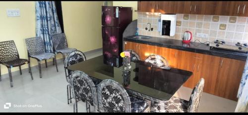 eine Küche mit Tisch und Stühlen und einem Kühlschrank in der Unterkunft palolem beach residency in Canacona