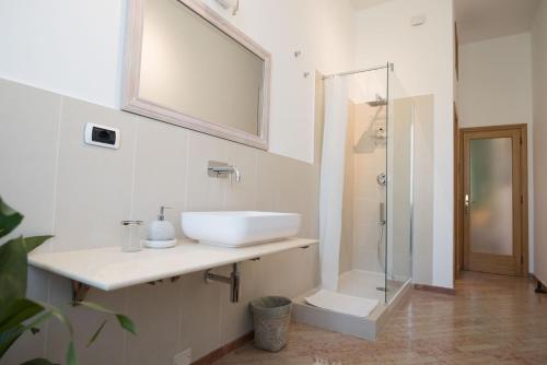 a white bathroom with a sink and a shower at Maison Étoile in Florence