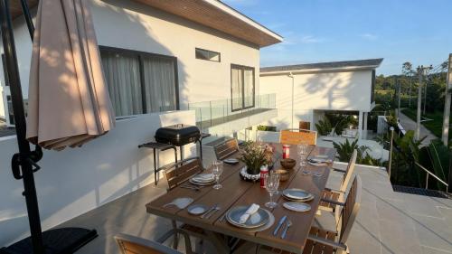 a wooden table on the balcony of a house at Kohkohnut villa 3BR Villa with Private Pool in Bophut Near Fisherman in Amphoe Koh Samui