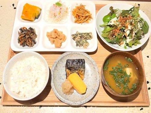 熊本奥库斯酒店的装有食物盘子和食物碗的木托盘