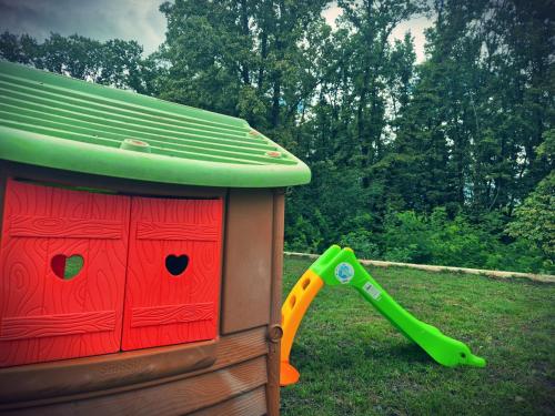 a toy dog house with a shovel in the grass at Kika apartmani-FREE PARKING- 7 km od centra in Zagreb