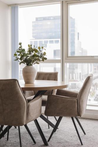 a table with two chairs and a vase with a plant at Exclusive 2BR Apartments By Luxus in Belfast