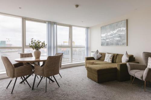 a living room with a couch and a table with chairs at Exclusive 2BR Apartments By Luxus in Belfast