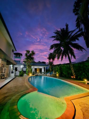 a swimming pool in front of a house at Sansuko Ville Panwa in Ban Bo Rae