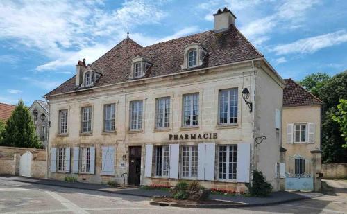 a large white building with a sign that reads pharmacy at Gîte du Pavillon 4 pers Wi-Fi Haute Marne in Arc-en-Barrois