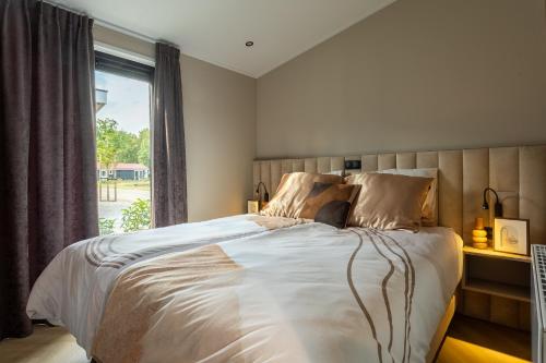 een slaapkamer met een groot bed en een raam bij Hillenaar in Huppel