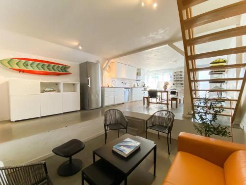 a living room with a couch and a table at Koala Surf House, en bord d'Océan, planches de surf et skates à disposition in Hossegor