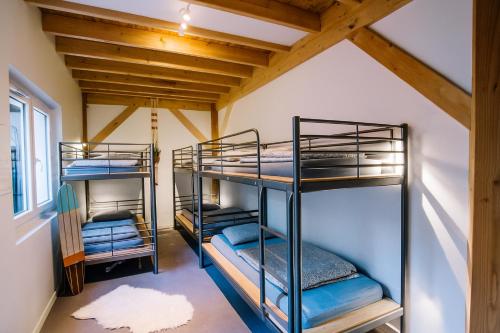 two bunk beds in a room with wooden ceilings at Koala Surf House, en bord d'Océan, planches de surf et skates à disposition in Hossegor