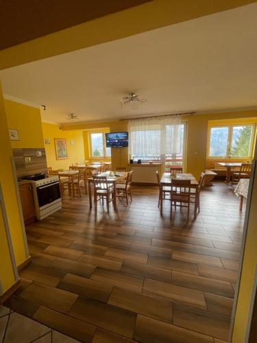 a dining room with tables and chairs and yellow walls at Dom Wiślańskie Wzgórze in Wisła