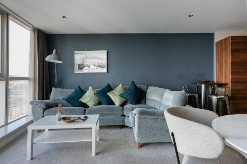 a living room with blue walls and a couch at Exclusive 2BR Apartments By Luxus in Belfast