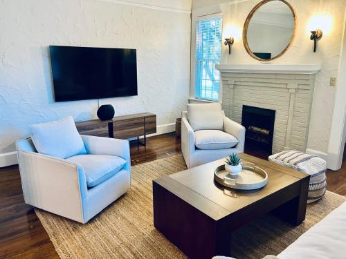 a living room with two chairs and a fireplace at Cozy house 15 mins to Fort Benning in Central Columbus in Columbus
