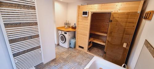 a small bathroom with a washer and dryer at Time Out Moments Haus mit eigener Sauna in Grafenau