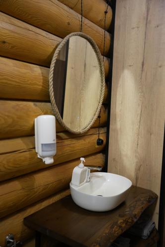 a bathroom with a white sink and a mirror at Дом из сруба in Koshi