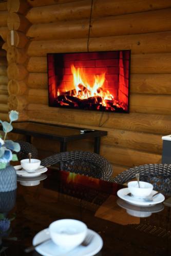 a fireplace in a log cabin with a table and chairs at Дом из сруба in Koshi