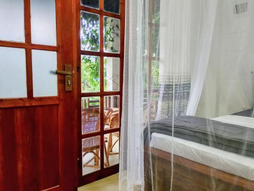 a bedroom with a door open to a balcony at 3 Arch Villa in Ella