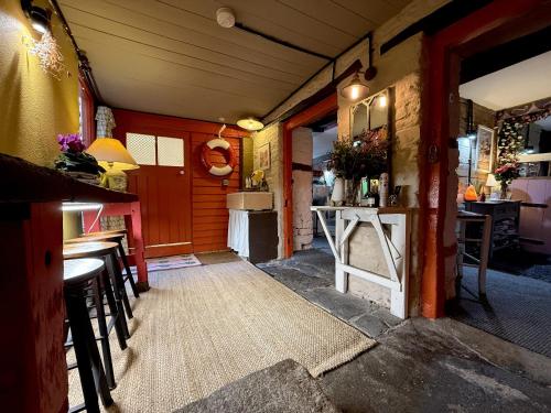 ein Raum mit einer Bar mit Stühlen und einem Tisch in der Unterkunft Charming two-bedroom apartment, One Drake Road, Tavistock in Tavistock