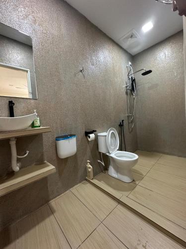 a bathroom with a toilet and a sink at Cerya Kampung Inn in Cherating