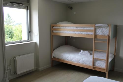 Sainte-EulalieにあるEspace Gerbierの窓のある部屋に二段ベッドが2つある